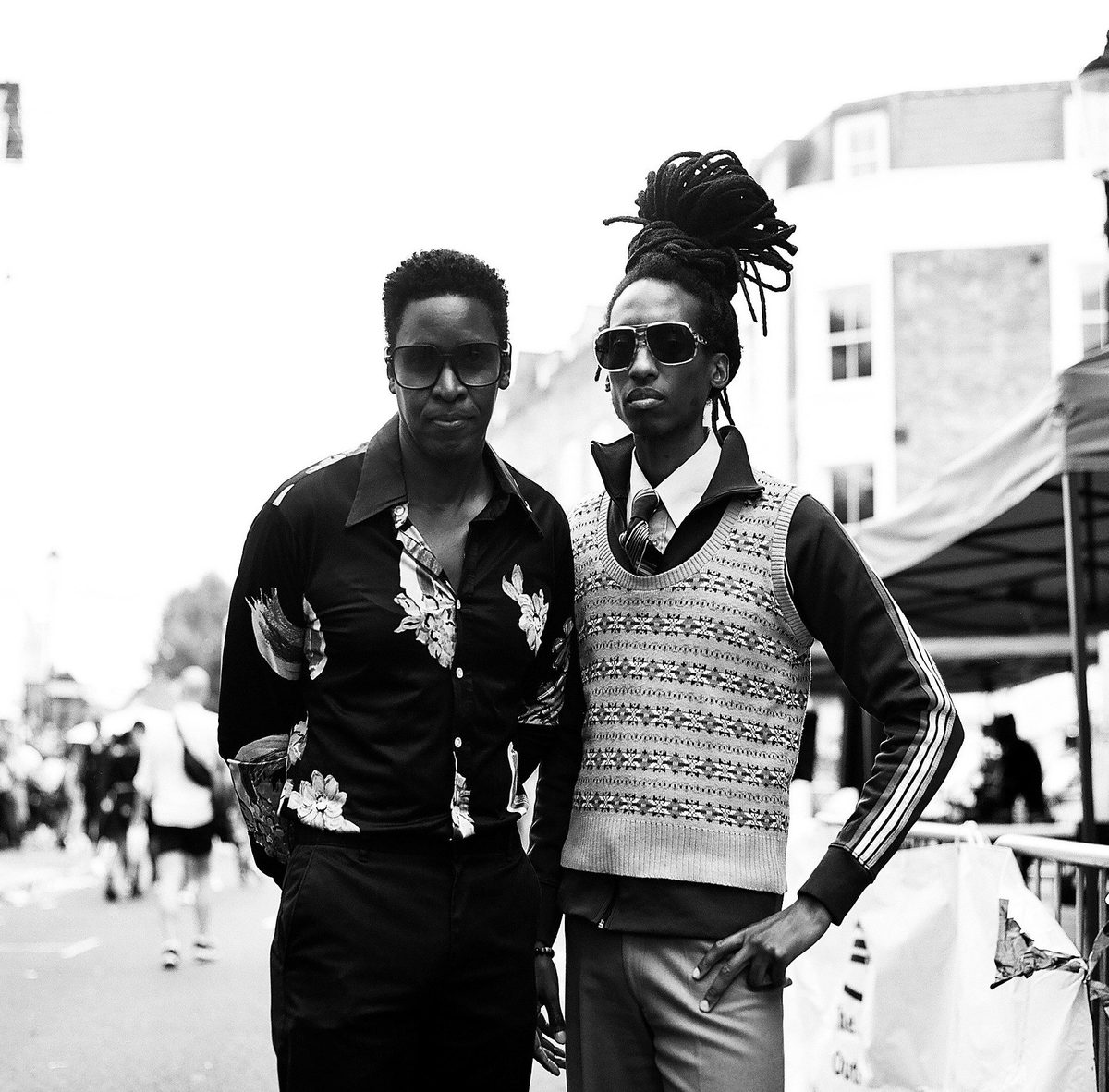 Two men in seventies style posing on a festival street, black and white