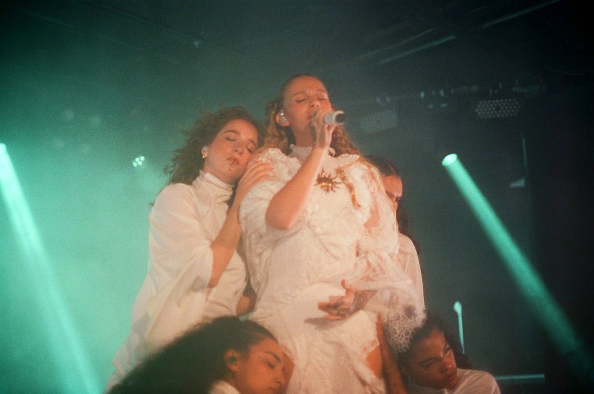 Singer held by dancers mid-performance