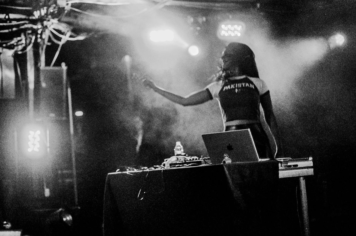 Performer reaching out from a smoky stage, black and white