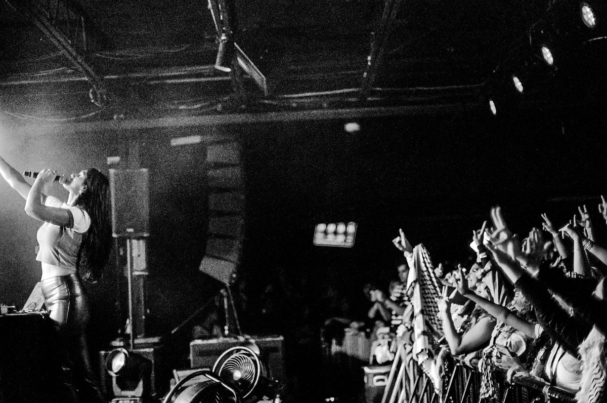 Performer and crowd reaching toward each other, black and white