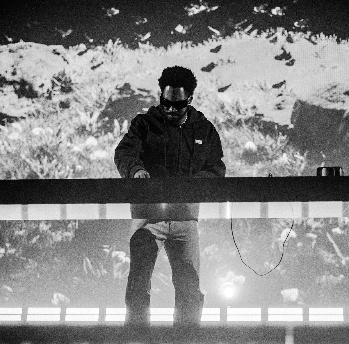 DJ in sunglasses at the booth, black and white