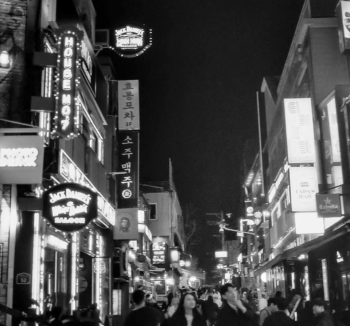 Night market under glowing lamps, black and white