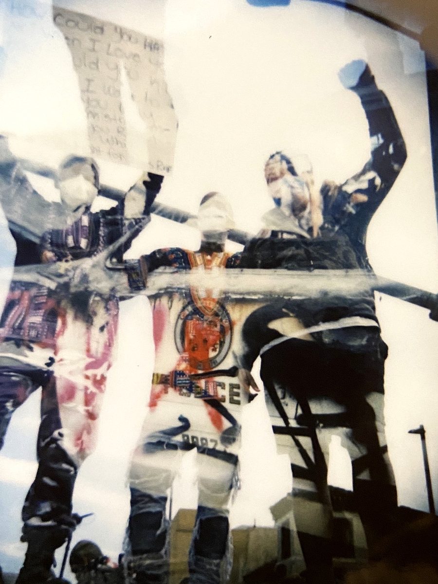 Double exposure of protesters with raised fists and signs on a truck